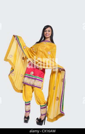 Voller Länge einer indischen Frau in Salwar Kameez stehend auf grauem Hintergrund Stockfoto