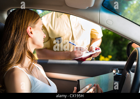 Polizei - junge Frau mit Polizist oder Polizist auf der Straße oder Verkehr, sie zeigen ihren Pass oder Führerschein Stockfoto