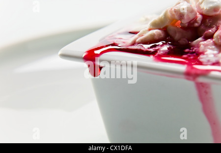 Hüttenkäse mit Kirschmarmelade auf einem weißen Teller. Stockfoto