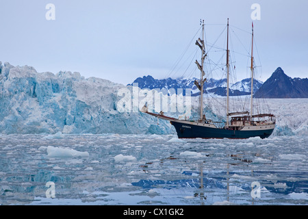 Gletscher und Großsegler / Barkentine Antigua unter Eisscholle Segeln mit Touristen in der Lilliehookfjorden, Svalbard, Spitzbergen Stockfoto