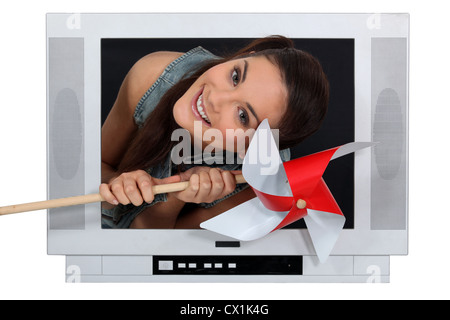 Frau, die sich aus TV mit einem Schleifer Stockfoto