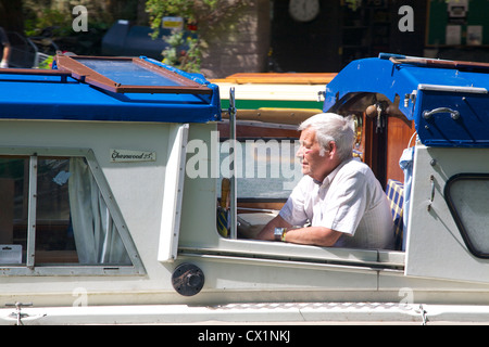 Mann auf einem engen Boot am Kai Llanfoist, Monmouthshire und Brecon Canal, Nr Abergavenny, Monmouthshire Stockfoto