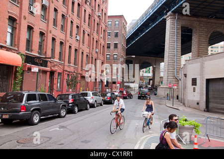 Radfahrer reiten auf Pearl Street unterhalb der Manhattan Bridge Überführung. Stockfoto