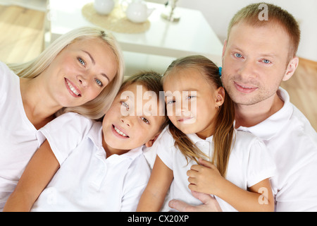 Porträt von glücklichen Eltern mit zwei Kindern, Blick in die Kamera zu Hause Stockfoto