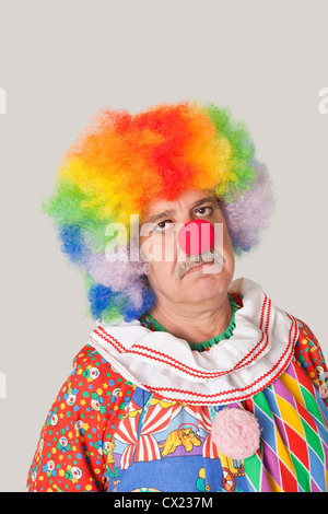 Porträt der traurige senior männlichen Clown vor farbigem Hintergrund Stockfoto