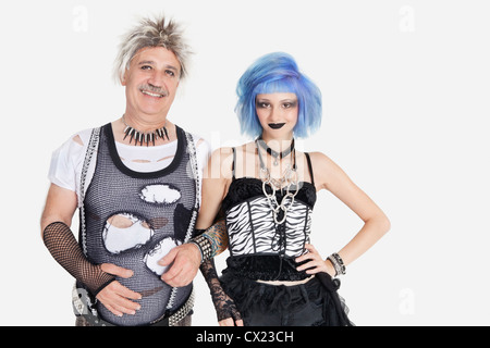 Porträt der jungen weiblichen Punk stehend Arm in Arm mit senior Mann trägt zerrissen Kleider über grauen Hintergrund Stockfoto