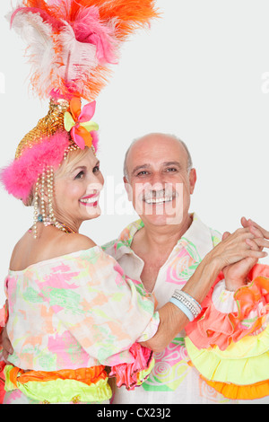 Porträt von älteres Paar brasilianische Outfits tanzen über grauen Hintergrund Stockfoto