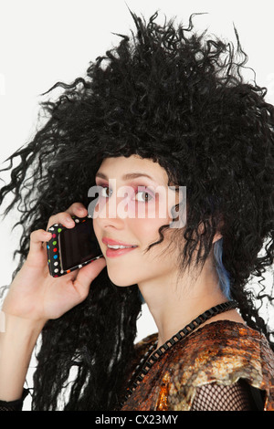 Schöne junge Gothic Frau mit toupierten Haaren mit Handy Stockfoto