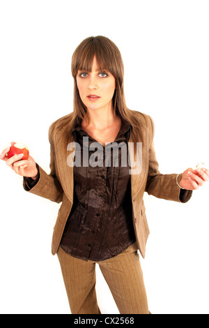 Junge Brünette Frau in braunen Anzug hält Apfel Stockfoto