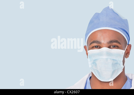 Nahaufnahme eines männlichen Arztes tragen Gesichtsmaske über hellblauen Hintergrund Stockfoto