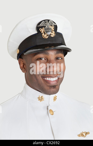 Porträt von glücklich junger afrikanischer Amerikaner US Navy Offizier auf grauem Hintergrund Stockfoto