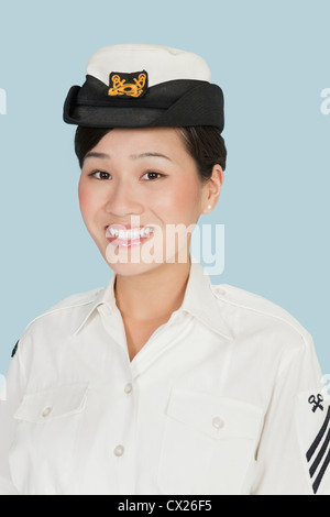 Porträt eines jungen schönen US Navy Offizier lächelnd auf hellblauem Hintergrund Stockfoto