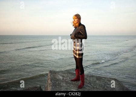 Blonde Mädchen den Sonnenuntergang am Meer Stockfoto