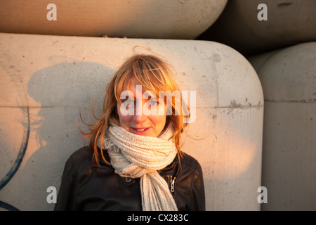 Blonde Mädchen flirten bei Sonnenuntergang in der Nähe von Industriegebiet Stockfoto