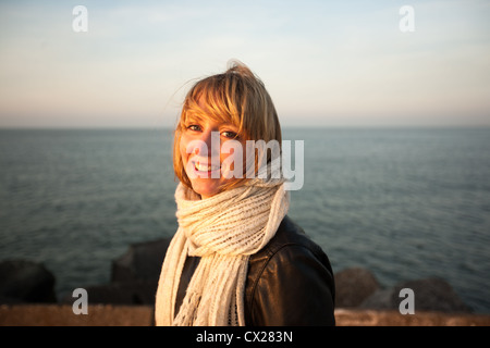 Blonde Mädchen flirten bei Sonnenuntergang am Meer Stockfoto