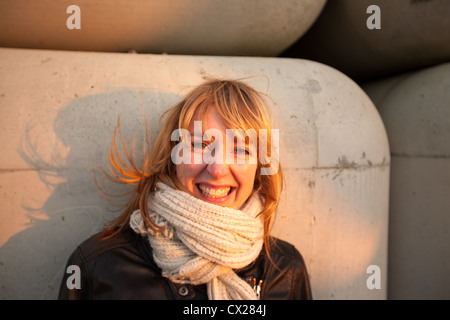 Blonde Mädchen flirten bei Sonnenuntergang in der Nähe von Industriegebiet Stockfoto