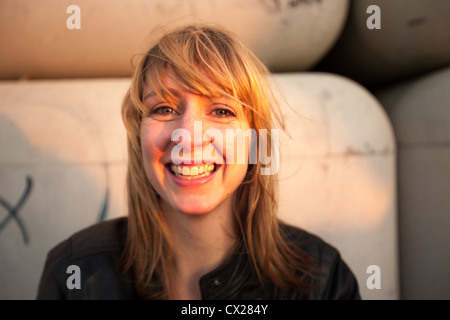 Blonde Mädchen flirten bei Sonnenuntergang in der Nähe von Industriegebiet Stockfoto