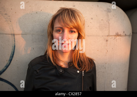 Blonde Mädchen flirten bei Sonnenuntergang in der Nähe von Industriegebiet Stockfoto