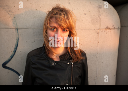 Blonde Mädchen flirten bei Sonnenuntergang in der Nähe von Industriegebiet Stockfoto