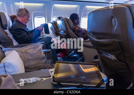 Passagiere von der Seite, sitzen auf den Sitzen, Innenborder von British Airways Flug, mit IPADS, Boeing 757 Flugzeug, First Class Section Cavbin Stockfoto