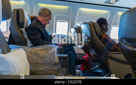 USA, Passagiere, die auf Sitzen sitzen, Kabine an Bord von british Airways, Flug, mit IPAD, Boeing 757 Flugzeug Stockfoto