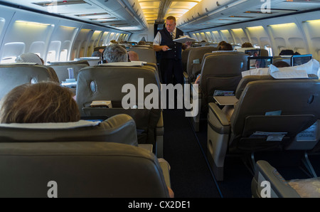 Steward arbeitet, Crowd People, innen, Innenborder, British Airways Flug, Boeing 757 Flugzeug, Gang, Kabinensitze von hinten Stockfoto