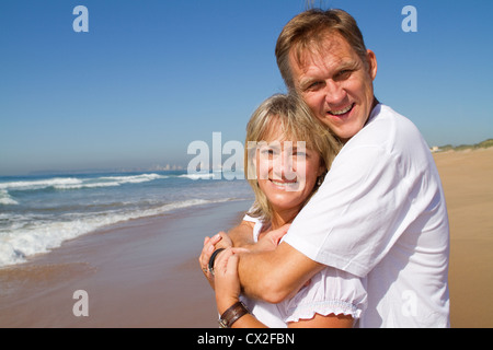 Happy Reife Liebespaar, umarmend an einem sonnigen Tag am Strand Stockfoto