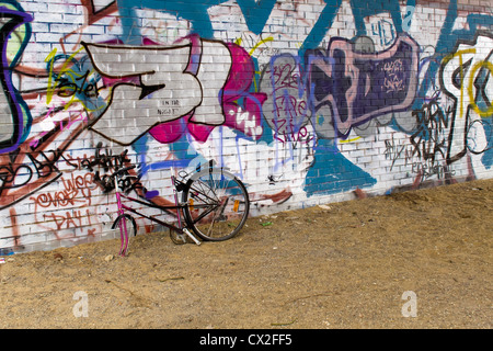 Der Berliner Mauer Region Staaken, West-Berlin ein geschändeter Fahrrad und Graffitiwand Stockfoto