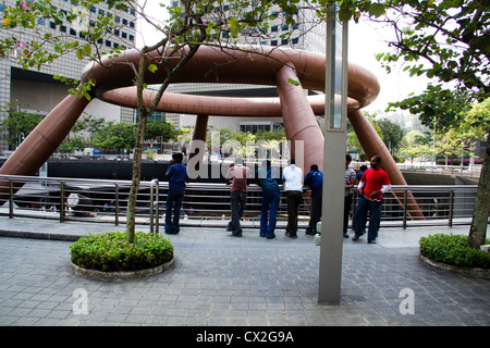 Touristen am Brunnen des Reichtums in Singapur. Der Brunnen des Reichtums ist eine große Struktur, befindet sich im Zentrum der Suntec City Stockfoto