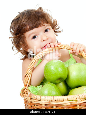 Entzückende kleine Mädchen mit grünem Apfel im Korb isoliert Studio gedreht Stockfoto