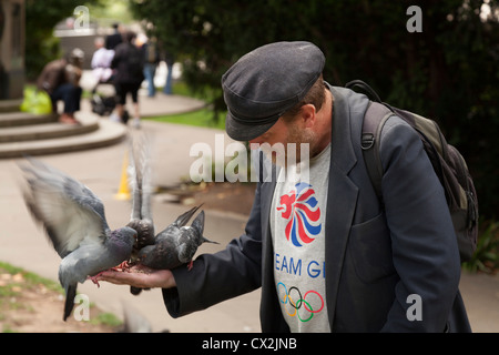 Mann in seiner Hand im Kirchhof der St. Pauls in London Tauben füttern. Stockfoto