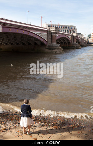 Frau an der Seite der Themse und Blackfriers Brücke in London Stockfoto