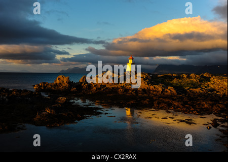 Norwegen, Lofoten. Hovsund am nördlichen Teil des Gimsøya. Ein kleiner Leuchtturm am Ende der großen Mole. Sonnenuntergang. Stockfoto