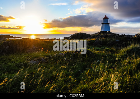 Norwegen, Lofoten. Hovsund am nördlichen Teil des Gimsøya. Ein kleiner Leuchtturm am Ende der großen Mole. Sonnenuntergang. Stockfoto