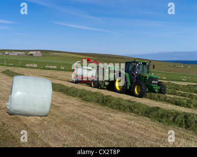 dh John Deere Traktor Ballenpressen ERNTE UK Rappen Feld Ernte Ballen Herstellung Maschinen Heupresse in Schottland Traktoren Ballen Stockfoto