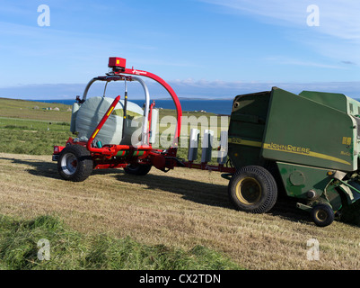 dh BALLENPRESSE ERNTE UK John Deere Traktor Ballenpressen Rappen Feldernte Ballenherstellung Maschinen Bauernhof Heu Landwirtschaft Maschine Rundwickler Stockfoto