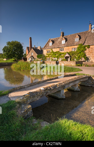 Stein-Steg und Hütten in der malerischen Cotswolds Dorf von Lower Slaughter, Gloucestershire, England. September 2012. Stockfoto