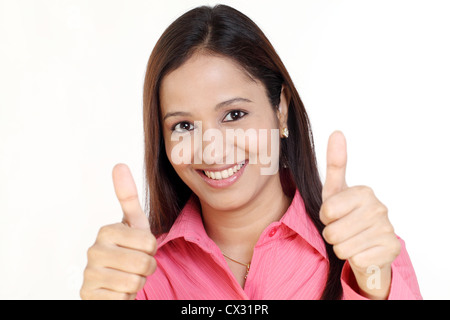 Attraktive junge Geschäftsfrau, die Daumen nach oben zeigen Stockfoto