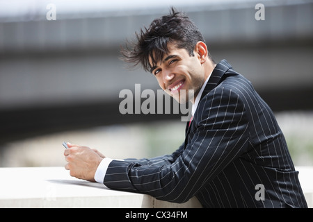 Porträt von lächelnden indischer Geschäftsmann im Nadelstreifenanzug im freien Stockfoto