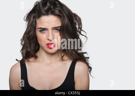 Porträt einer frustrierte junge Frau vor grauem Hintergrund Stockfoto