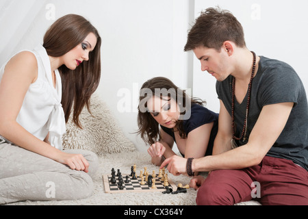 Junge Freunde spielen Schach auf sofa Stockfoto