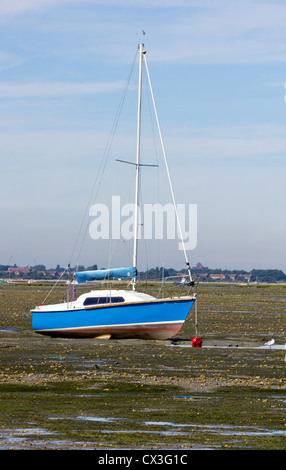 Blaues Boot bei Ebbe mit Mast, und rote Bouy festgemacht Stockfoto