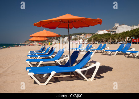 Sonnenschirm und Liegebetten am Strand, Calella De La Costa, Costa del Maresme, Katalonien, Spanien, Europa Stockfoto