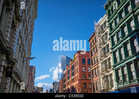 Alte Loft-Gebäude mit Feuerausbrüchen in der Broome Street in Soho-Cast Iron Historic District mit dem Glas Trump SoHo in Die Entfernung Stockfoto