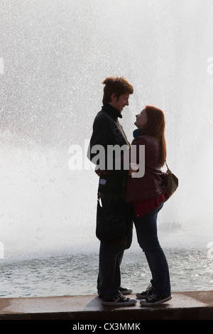 Junges Paar gegen Brunnen Silhouette Stockfoto