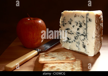 Ein Keil von Roquefort-Käse auf einem Brett mit Royal Gala Apfel, Messer und Creme-Cracker-Kekse Stockfoto