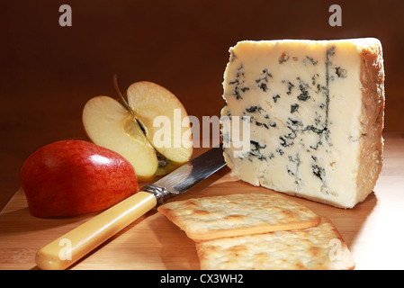 Ein Keil von Roquefort-Käse auf einem Brett mit Royal Gala Apfel, Messer und Creme-Cracker-Kekse Stockfoto