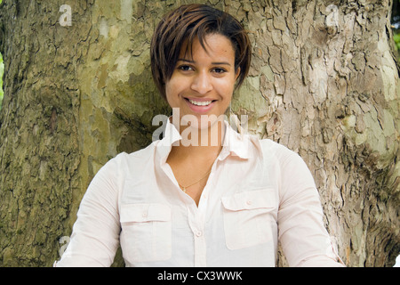 Porträt der Frau gegen Baumstamm. Stockfoto