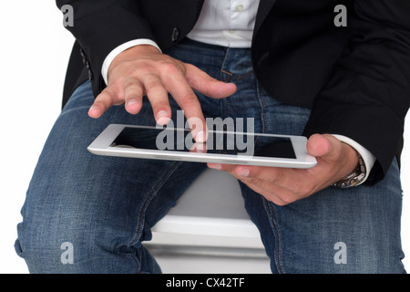 Ein Mann mit Jeans auf einem TabletPC arbeiten mit ist er Hand Stockfoto