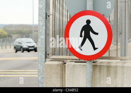 Runde Straße Zeichen, die bedeutet "keine Fußgänger erlaubt". Hält Menschen zu Fuß auf dem Eintrag Weg zu einem geschäftigen Flughafen Stockfoto